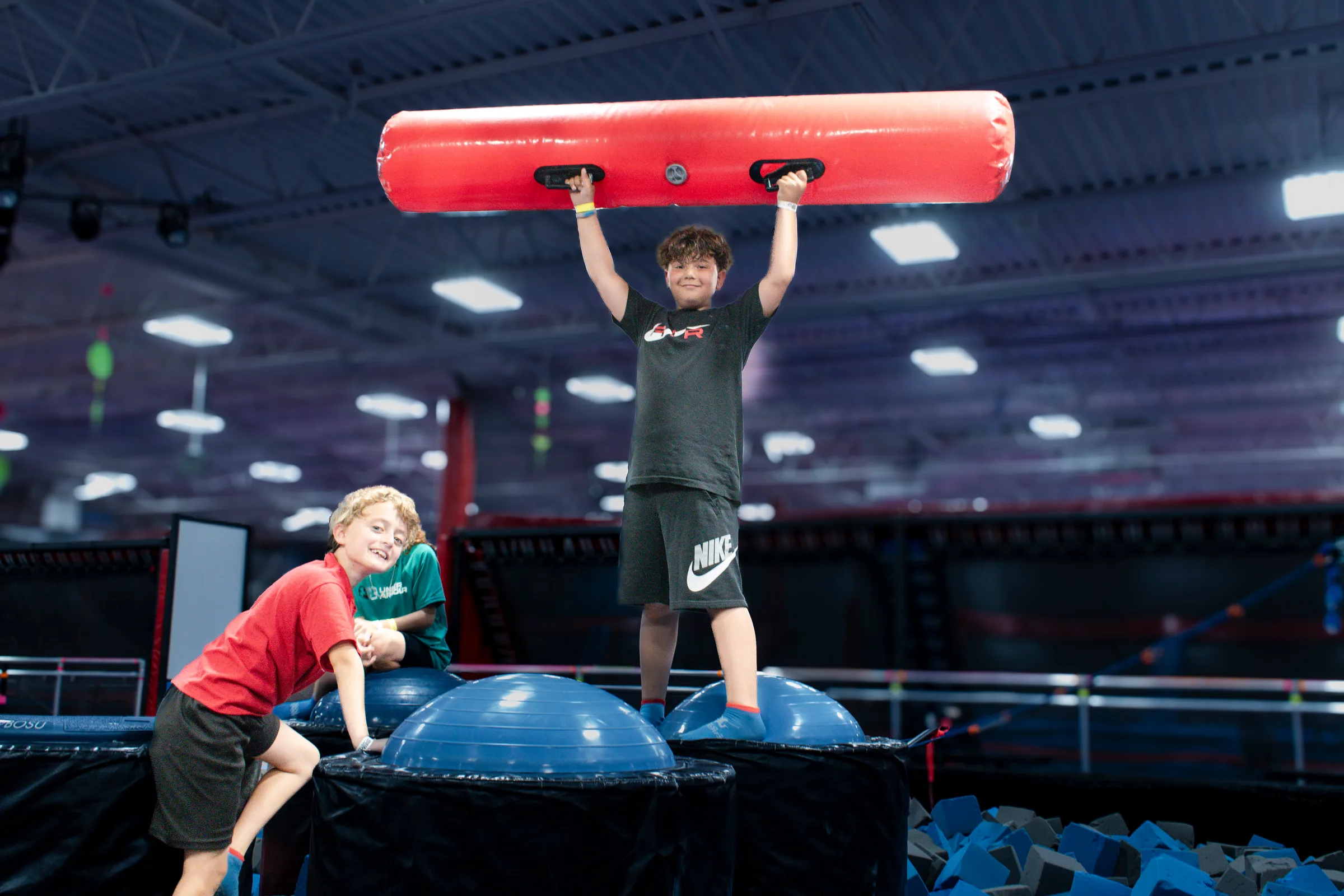 Kids on the Battle Beam platforms above the foam pit at AeroSports London